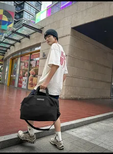Detailed view of the black travel duffel bag showing large capacity and sturdy handles.