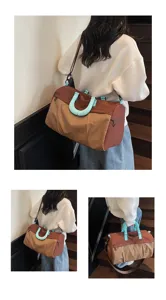 Detail view of large capacity travel duffel bag with stylish grid pattern and blue handles.