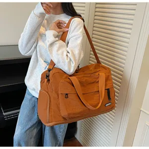 Detailed view of the large capacity brown travel duffel bag showing front pocket and side compartment.