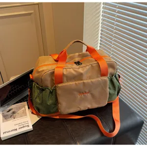 Spacious travel duffel bag in khaki with vibrant orange straps and green mesh side pockets.