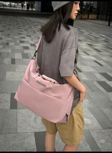 Large capacity travel duffel bag for women, stylish pink gym shoulder bag for weekend trips.
