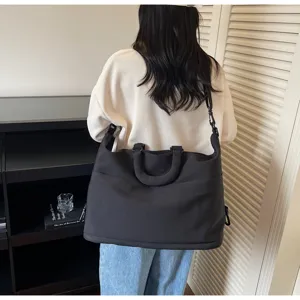 Vue détaillée du grand sac de voyage noir pour les déplacements, le fitness et le yoga.