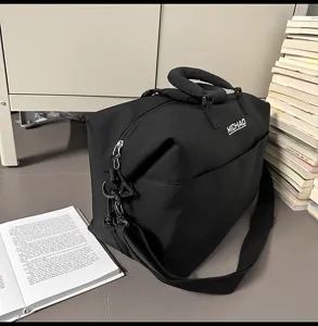 Black travel duffel bag detail, large capacity gym luggage bag with shoulder strap and handles.