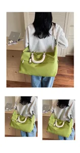 Detail view of large capacity travel duffel bag in green with comfortable white handles.