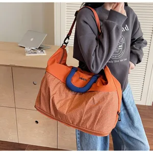Detailed lifestyle view of lightweight checkered travel duffel bag with handles and strap.