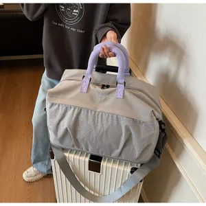 Detailed view of the lightweight travel duffel bag with comfortable purple handle and strap.