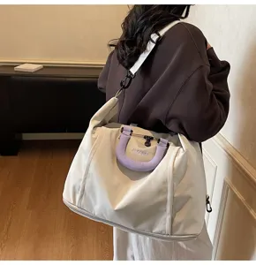Large capacity women travel duffel bag, waterproof shoulder luggage bag with purple handle.