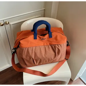 Detailed view of the large capacity travel duffel bag with contrasting orange and blue design.