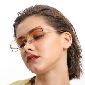 Close-up detail of trendy rimless sunglasses featuring gradient orange lenses and slim metal temples.