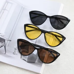 Retro cat eye sunglasses for women, oversized black frame with dark, yellow and brown lenses.