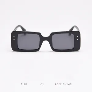 Square frame sunglasses detail, classic black thick rim with metal rivet accents on sides.
