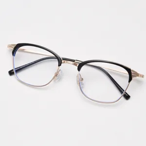 Close-up of retro half-rim metal glasses frame in black and gold, elegant daily eyewear detail.