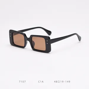Detailed view of black square polarized sunglasses with brown lenses, stylish street fashion.