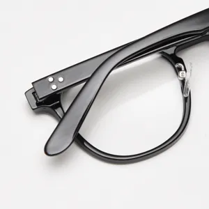 Detailed view of black vintage optical glasses frame temple hinge and classic retro rim shape.