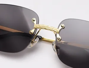 Luxury rimless sunglasses with gold carved bridge and dark gradient lenses for stylish vintage look.