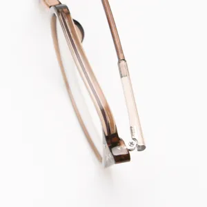 Primer plano de una montura de gafas marrón transparente con bisagras cuadradas elegantes.