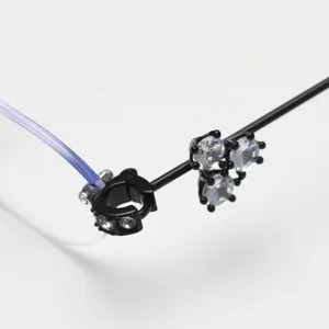 Detailed close-up of rimless glasses frame hinge with black rhinestone crystal decor.