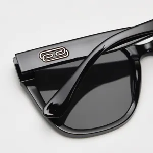Close-up detail of stylish black TR90 large frame sunglasses with metal temple logo.