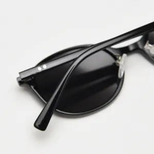 Close up detail of black oval polarized sunglasses frame, retro style temple rivet design.
