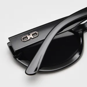 Black retro oval cat-eye polarized sunglasses detail view with metal temple logo accent.