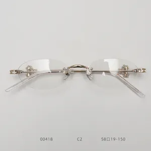 Detailed view of luxury rimless oval eyeglasses frame with sparkling rhinestones and metal accents.