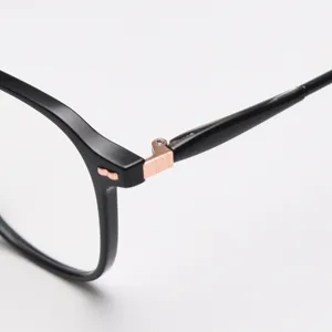 Montatura per occhiali nera con elegante dettaglio a cerniera in metallo color oro rosa alla moda.