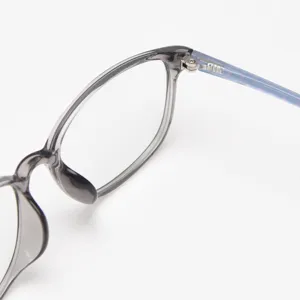 Detail shot of stylish TR90 eyeglasses hinge, grey translucent frame and blue patterned temple.