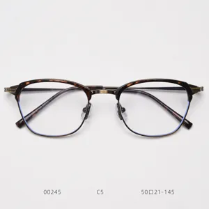 Detailed view of vintage metal half-rim glasses frame with tortoise shell browline.
