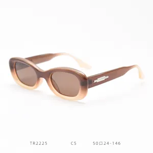 Detail view of brown gradient oval sunglasses with metal temple accent, retro style.