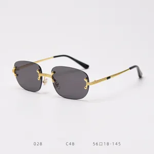 Detailed view of luxury rimless sunglasses with gold metal temples and dark grey lenses.