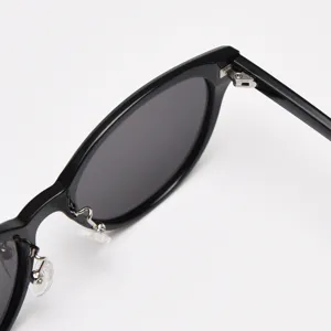 Close-up detail of black TR90 cat-eye sunglasses frame, metal hinge and nose pad view.