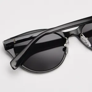 Close-up detail shot of black vintage cat-eye sunglasses frame, clear hinges and temple design.