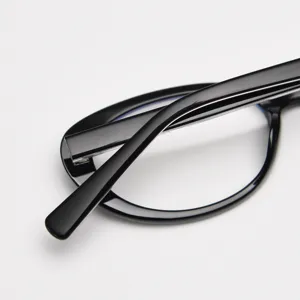 Close-up detail of black oval optical glasses frame, showcasing smooth glossy finish.