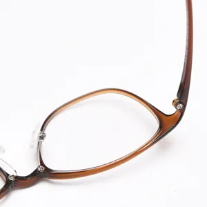 Close-up detail of stylish brown optical glasses frame showing hinge and rim structure.