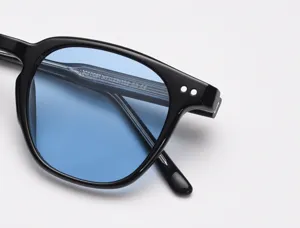 Gros plan détaillé de lunettes de soleil tendance à monture noire et verres bleus élégants.