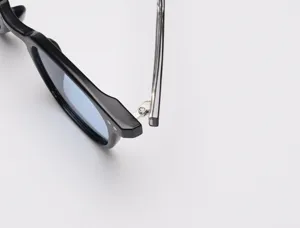 Vue detaillee de lunettes de soleil polarisees avec monture en acetate noir et charniere.