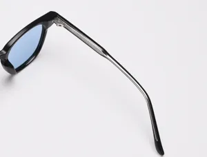 Vue de détail de lunettes de soleil polarisées élégantes avec monture noire et verres bleus.
