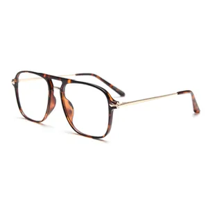 Monture de lunettes pilote double pont rétro avec motif écaille et branches dorées.