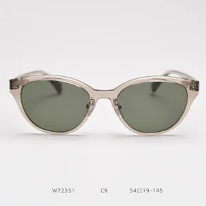 Detail shot of transparent champagne cat-eye sunglasses with dark green lenses, clear specs.