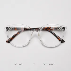 Clear round eyeglass frames with tortoise shell temples and gothic cross metal decor details.