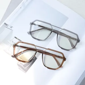 Vue détaillée de montures de lunettes rétro tendance à double pont en gris et marron transparent.