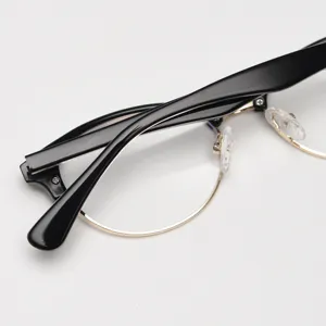 Primo piano dettagliato della montatura per occhiali retro browline nera e oro mezza montatura.