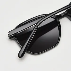 Gros plan détaillé de la monture de lunettes de soleil polarisées noires, rétro minimaliste.