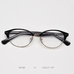 Vista dettagliata della montatura per occhiali semi-rimless nera e oro con naselli trasparenti.