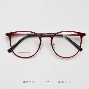 Close-up detail of vintage round optical glasses frame in stylish dark red plastic steel.