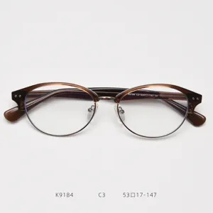 Vista dettaglio montatura occhiali browline marrone, stile classico ovale metallo acetato.