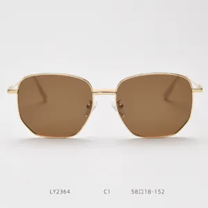 Detail shot of stylish golden metal polygon sunglasses with brown lenses, elegant and modern.
