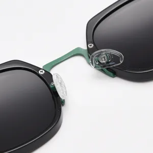Close-up detail of trendy sunglasses frame, metal bridge and nose pads, modern style.