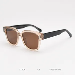 Close-up detail of stylish oversized fashion sunglasses with clear frame and brown lenses.