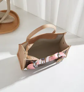 Borsa tote monogram chic con elegante foulard di seta rosa, manici beige.